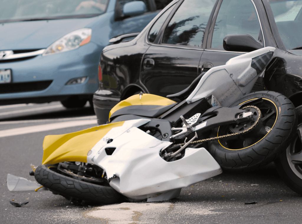 A motorcycle rests on its side along the roadside, indicating a possible accident or mechanical failure