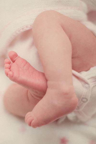 A close-up of a baby's feet resting in a soft diaper, showcasing tiny toes and delicate skin